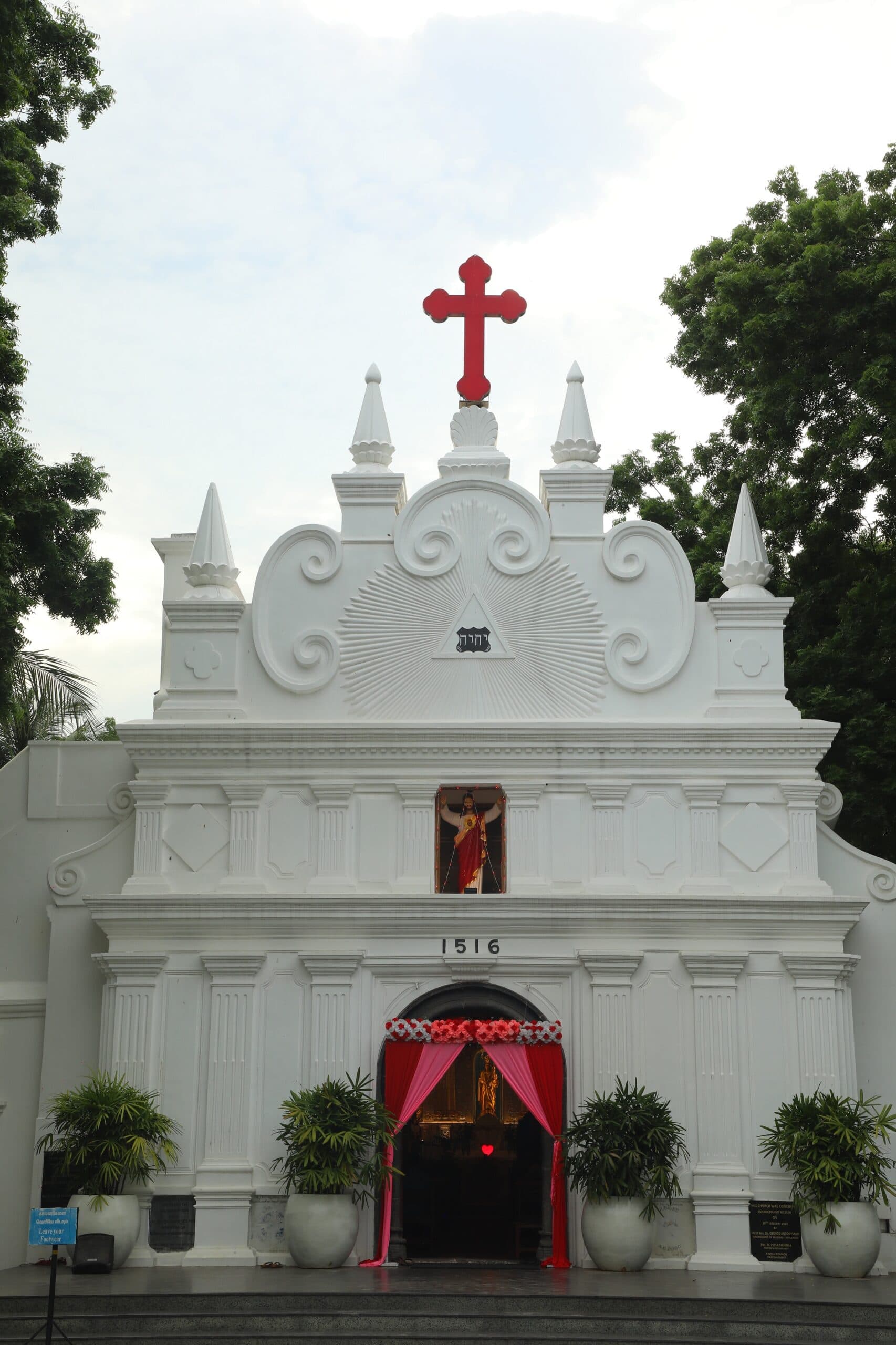 The white façade of Luz Church, built in 1516, crowned with its red cross